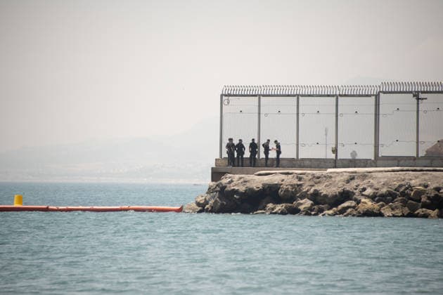 (260815) -- CEUTA, Aug. 15, 2026 -- Security personnel work at the border of Ceuta, Spain, Aug. 15, 2026. More than 72,000 migrants crossed irregularly into Ceuta from neighboring Morocco on July 30 and 31, according to the Spanish government. Most returned to Morocco later, while thousands remain in the enclave.Security was also tightened along the border ahead of Saturday after calls for another mass crossing circulated on social media. Moroccan security forces intercepted hundreds of migrants attempting to reach the border area, while Ceuta reported no influx on a scale comparable to that seen in late July. ) SPAIN-CEUTA-VIEW ChengxMin 