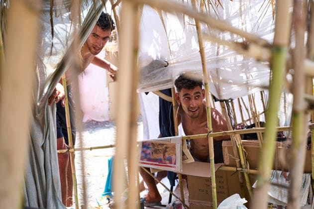 (260815) -- CEUTA, Aug. 15, 2026 -- Irregular migrants rest in a makeshift shelter in Ceuta, Spain, Aug. 15, 2026. More than 72,000 migrants crossed irregularly into Ceuta from neighboring Morocco on July 30 and 31, according to the Spanish government. Most returned to Morocco later, while thousands remain in the enclave.Security was also tightened along the border ahead of Saturday after calls for another mass crossing circulated on social media. Moroccan security forces intercepted hundreds of migrants attempting to reach the border area, while Ceuta reported no influx on a scale comparable to that seen in late July. ) SPAIN-CEUTA-VIEW MengxDingbo 