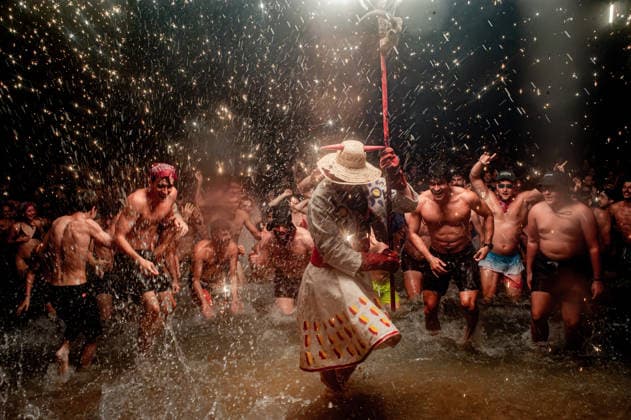 August 15, 2026, Badalona, Spain: People react as a Correfoc devil enters the sea during the August Festival in Badalona, north of Barcelona. The Correfoc, a traditional Catalan celebration featuring fireworks and fire-spitting performers, ends in the waters of Badalona beach. Badalona Spain  - ZUMAb137 20260815_fap_b137_006 Copyright: xJordixBoixareux