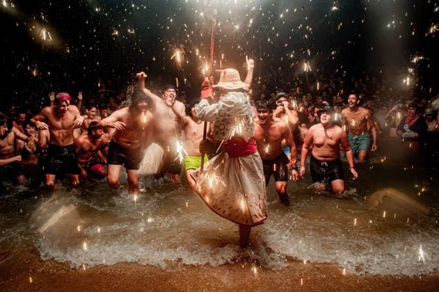 August 15, 2026, Badalona, Spain: People react as a Correfoc devil enters the sea during the August Festival in Badalona, north of Barcelona. The Correfoc, a traditional Catalan celebration featuring fireworks and fire-spitting performers, ends in the waters of Badalona beach. Badalona Spain - ZUMAb137 20260815_fap_b137_007 Copyright: xJordixBoixareux