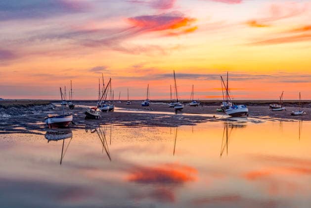 News Bilder des Tages August 16, 2026, Wells Next The Sea, Norfolk, UK: Wells Next The Sea UK. Colourful dawn skies this morning over the boats moored in Wells-Next-The-Sea on the Norfolk coast. Wells Next The Sea UK  - ZUMAl94_ 20260816_zaf_l94_002 Copyright: xAndrewxMccarenx