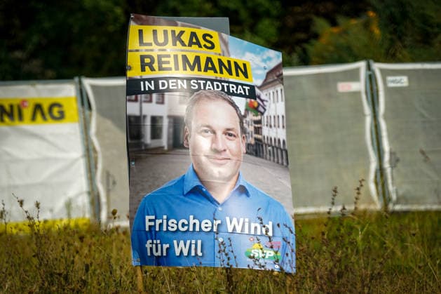 Schweiz: Politik, Wahlkampf in Wil (SG); Wahlplakat der Schweizerischen Volkspartei (SVP) mit dem Kandidaten Lukas Reimann und der Aufschrift Lukas Reimann in den Stadtrat Frischer Wind für Wil. Das Plakat steht am Strassenrand auf einer Grünfläche. Symbolbild für Kommunalpolitik, Wahlen, SVP, Stadt Wil und politischen Wahlkampf. *** Swiss Politics, Election Campaign in Wil, SG: Election poster for the Swiss People s Party (SVP) featuring candidate Lukas Reimann and the slogan Lukas Reimann for City Council—A Breath of Fresh Air for Wil. The poster is displayed on the side of the road in a green space. Symbolic image representing local politics, elections, SVP, the city of Wil, and political campaigns Copyright: xJOERANxSTEINSIEKx