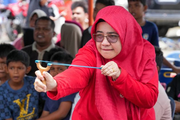 August 16, 2026, Banda Aceh, Aceh, Indonesia: A woman is seen intently aiming at a target while participating in a slingshot competition held to celebrate Indonesia s 81st Independence Day in Banda Aceh, Aceh Province, Indonesia, on Sunday. Residents organized various traditional competitions to foster a sense of togetherness and entertain the local community in celebration of Independence Day. Banda Aceh Indonesia - ZUMAi115 20260816_zip_i115_011 Copyright: xMuhammadxIqbalx