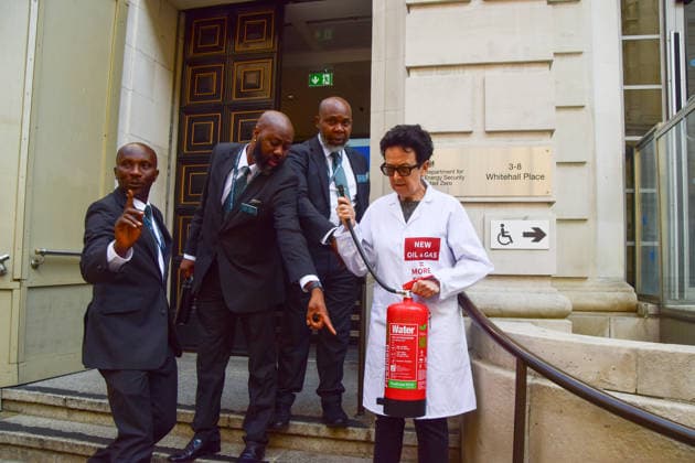 August 17, 2026, London, England, United Kingdom: Security personnel try to move a climate activist from the group Scientists On Survival standing outside the Department for Energy Security and Net Zero (DESNZ) in Westminster with a fire extinguisher after spraying the building with water in protest against Rosebank, as the public consulation on the North Sea oil and gas field concludes. London United Kingdom - ZUMAv130 20260817_zip_v130_024 Copyright: xVukxValcicx