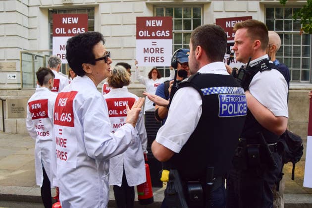 August 17, 2026, London, England, United Kingdom: Police officers speak to climate activists from the group Scientists On Survival outside the Department for Energy Security and Net Zero (DESNZ) in Westminster after they sprayed the building with water using fire extinguishers in protest against Rosebank, as the public consulation on the North Sea oil and gas field concludes. London United Kingdom - ZUMAv130 20260817_zip_v130_028 Copyright: xVukxValcicx