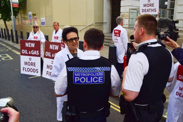 August 17, 2026, London, England, United Kingdom: Police officers speak to climate activists from the group Scientists On Survival outside the Department for Energy Security and Net Zero (DESNZ) in Westminster after they sprayed the building with water using fire extinguishers in protest against Rosebank, as the public consulation on the North Sea oil and gas field concludes. London United Kingdom - ZUMAv130 20260817_zip_v130_029 Copyright: xVukxValcicx