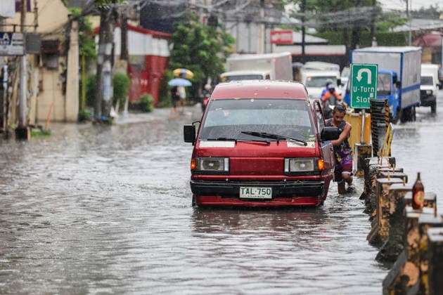 (260817) -- QUEZON CITY, Aug. 17, 2026 -- A stranded vehicle is pushed through floodwater in Quezon City, the Philippines, on Aug. 17, 2026. The Philippine government has suspended in-person classes in Metro Manila and 12 other provinces as heavy rains from tropical cyclones and the southwest monsoon continue to batter the country, local media reported on Monday. The extreme rainfall has triggered severe flooding and landslides across the nation. The well-known flood-control corruption scandal has left key infrastructure unfinished or poorly maintained, further straining the country s disaster response, local media reported. ) THE PHILIPPINES-QUEZON CITY-SOUTHWEST MONSOON-FLOOD RouellexUmali 