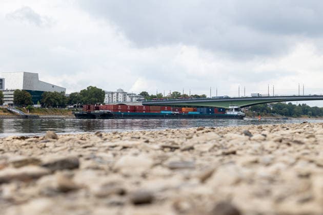 Binnenschiff fährt bei Niedrigwasser auf dem Rhein in Bonn Bonn, 17. August 2026: Ein mit Containern beladenes Binnenschiff fährt bei deutlich niedrigem Wasserstand auf dem Rhein in Bonn. Der Rhein führt derzeit aufgrund anhaltender Trockenheit und geringer Niederschläge außergewöhnlich wenig Wasser. Am Pegel Bonn wurde am 17. August ein Wasserstand von rund 62 bis 64 Zentimetern gemessen. Der für Bonn angegebene Gleichwertige Wasserstand (GlW) liegt bei 142 Zentimetern. Das Niedrigwasser erschwert die Binnenschifffahrt und kann dazu führen, dass Schiffe ihre Ladung reduzieren müssen. Bonn Beuel Nordrhein-Westfalen Deutschland *** Inland waterway vessel navigates the Rhine in Bonn during low water levels Bonn, August 17, 2026 A bar
