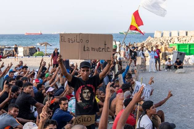 August 17, 2026, Ceuta, Spain: CEUTA, SPAIN Ã¢â‚¬ AUGUST 17, 2026: More than 100 migrants, most of them Moroccan, have been protesting for days in front of National Police vans during the daily food distribution provided by the Spanish Red Cross at TrampoloÂ­n Beach. Ã¢â‚¬oeNo asylum, no foodÃ¢â‚¬Â is the chant repeated by the migrants on the sand, while African migrants continue to stay in the temporary accommodation facilities set up on the Ceuta beach. Authorities are expected to clear the beach in the coming days and transfer the migrants to four reception facilities announced today by SpainÃ¢â‚¬â ¢s Minister for Migration, Elma Saiz. Ceuta Spain  - ZUMAq101 20260817_zna_q101_078 Copyright: xAntonioxSemperex