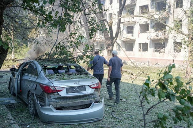 August 18, 2026, Kramatorsk, NULL, Ukraine: Two people walk past a damaged car following a Russian strike on Kramatorsk, west of the Donbas region in Ukraine, on the morning of August 18, 2026. Kramatorsk Ukraine - ZUMAa252 20260818_zip_a252_010 Copyright: xDavidxAllignonx