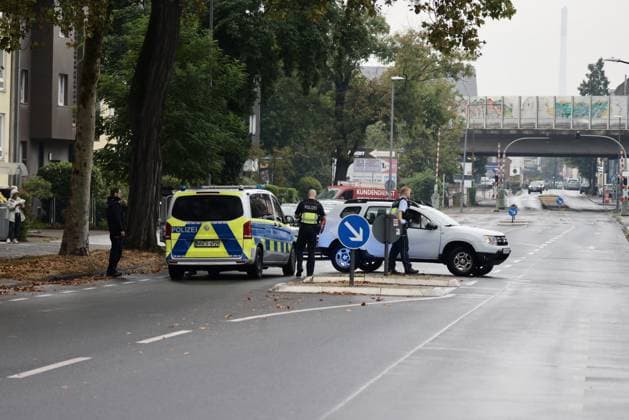 Police seal off Erlenhofstrasse in Cologne after reports of gunshots from attic COLOGNE, GERMANY - AUGUST 18: German police officers secure the cordoned-off perimeter around Erlenhofstrasse during an ongoing armed operation in the Niehl district of Cologne, Germany, on August 18, 2026. Following reports that a man fired gunshots into the air from an attic apartment, numerous police units were dispatched to the scene, shutting down Erlenhofstrasse and surrounding connecting roads to vehicular and pedestrian traffic while urging the public to avoid the area. Kadir Ilboga Anadolu Cologne Germany. Editorial use only. Please get in touch for any other usage.  Copyright: x2026xAnadoluxKadirxIlbogax