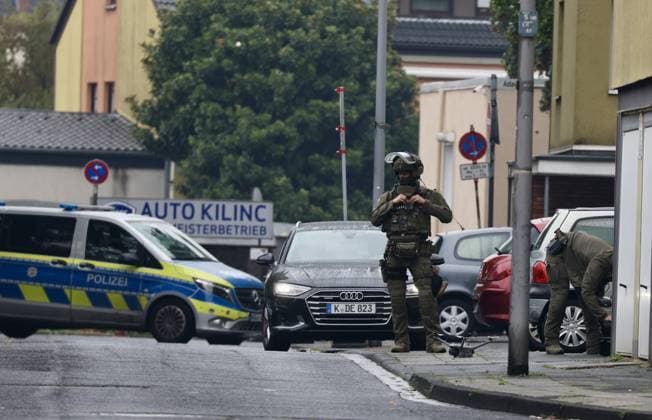 Police seal off Erlenhofstrasse in Cologne after reports of gunshots from attic COLOGNE, GERMANY - AUGUST 18: German police officers secure the cordoned-off perimeter around Erlenhofstrasse during an ongoing armed operation in the Niehl district of Cologne, Germany, on August 18, 2026. Following reports that a man fired gunshots into the air from an attic apartment, numerous police units were dispatched to the scene, shutting down Erlenhofstrasse and surrounding connecting roads to vehicular and pedestrian traffic while urging the public to avoid the area. Kadir Ilboga Anadolu Cologne Germany. Editorial use only. Please get in touch for any other usage.  Copyright: x2026xAnadoluxKadirxIlbogax