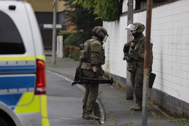 Police seal off Erlenhofstrasse in Cologne after reports of gunshots from attic COLOGNE, GERMANY - AUGUST 18: German police officers secure the cordoned-off perimeter around Erlenhofstrasse during an ongoing armed operation in the Niehl district of Cologne, Germany, on August 18, 2026. Following reports that a man fired gunshots into the air from an attic apartment, numerous police units were dispatched to the scene, shutting down Erlenhofstrasse and surrounding connecting roads to vehicular and pedestrian traffic while urging the public to avoid the area. Kadir Ilboga Anadolu Cologne Germany. Editorial use only. Please get in touch for any other usage.  Copyright: x2026xAnadoluxKadirxIlbogax