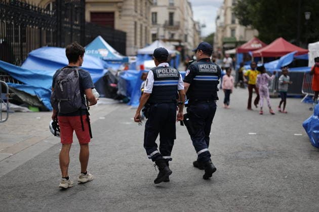 Homeless people camp outside the Paris Centre City Hall - Paris Police forces walk next to homeless people with children have set up their camp and have put up tents outside the Paris Centre City Hall, in Paris on August 18, 2026. After being removed from the forecourt of the Samu Social headquarters in Paris. Photo by Raphael Lafargue ABACAPRESS.COM Paris France  Copyright: xLafarguexRaphael ABACAx
