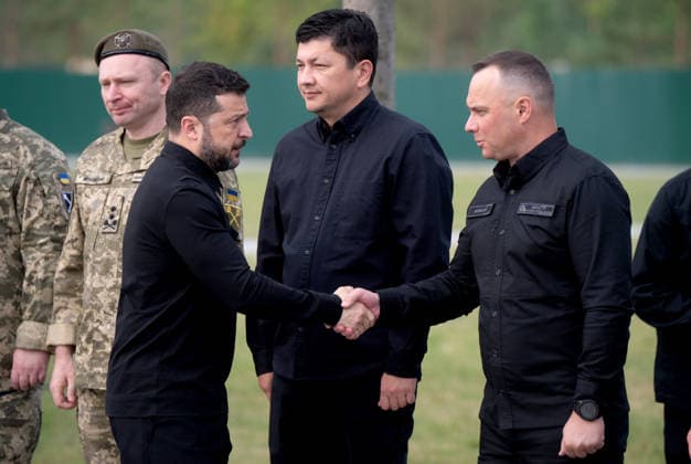 President of Ukraine Volodymyr Zelenskyy (L, front) shakes hands with Minister of Internal Affairs of Ukraine Ivan Vyhivskyi in the presence of Commander-in-Chief of the Armed Forces of Ukraine Mykhailo Drapatyi and Minister for Veterans Affairs of Ukraine Vitalii Kim (L to R, back) during the solemn reburial ceremony of Colonel Yevhen Konovalets, first head of the Organisation of Ukrainian Nationalists (OUN) and colonel of the Army of the Ukrainian People’s Republic (UNR), at the National Military Memorial Cemetery in Kyiv region, Ukraine, August 18, 2026. On August 11, 2026, Konovalets’ remains were exhumed at Crooswijk General Cemetery in Rotterdam, the Netherlands, where they had rested since his assassination by a Soviet agent in May 1  Copyright: xDanyloxAntoniukx
