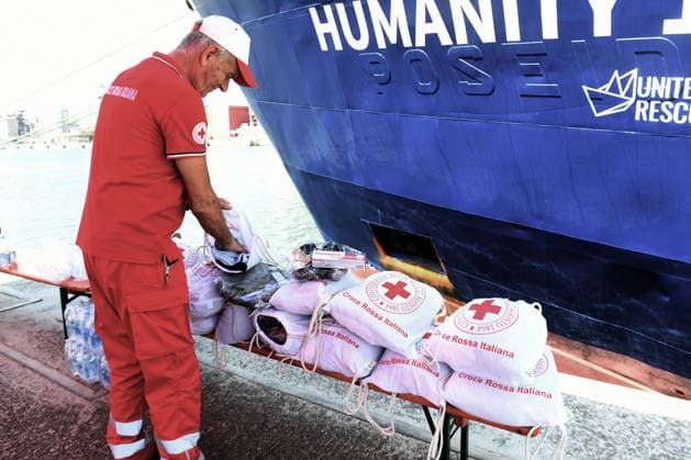 August 18, 2026, Ravenna, Rome, Italy: The NGO ship Humanity 1 has arrived in the port of Ravenna with 73 migrants on board, 15 of whom are minors and five women, one of whom is a minor. Most are from Sudan, with others from Senegal. This is the 28th landing in the port of Ravenna. In the photo, a Red Cross worker arranges the bags containing first aid items such as slippers, soap, toothpaste, and clothing to be distributed to all the migrants. Ravenna Italy  - ZUMAa289 20260818_zia_a289_019 Copyright: xAgfx