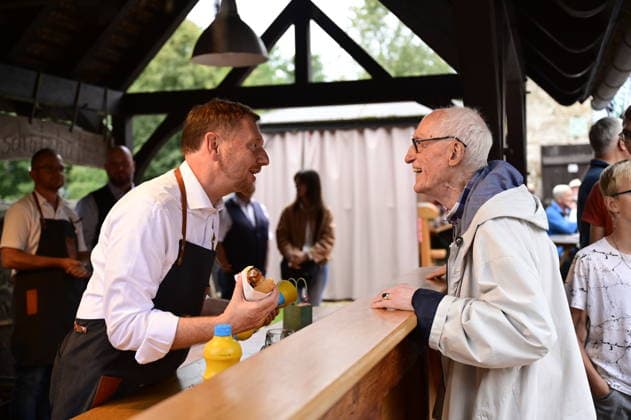 Michael Kretschmer und Hansheinrich Schnorr von Carolsfeld beim Bürgergesprächs-Format Kretschmer grillt mit Sachsens Ministerpräsident Michael Kretschmer im Pfarrhof der St. Katharinen Kirche in Arnsdorf (Gemeinde Vierkirchen, Landkreis Görlitz) am 18.08.2026. *** Michael Kretschmer and Hansheinrich Schnorr von Carolsfeld at the public forum Kretschmer Grills with Saxony’s Minister President Michael Kretschmer in the rectory of St. Katharinen Church in Arnsdorf, Vierkirchen municipality, Görlitz district, on August 18, 2026 Copyright: xMatthiasxWehnertx