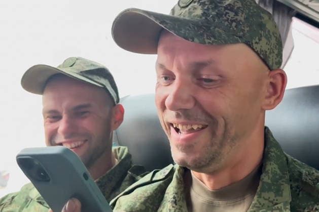 BELARUS - AUGUST 19, 2026: A serviceman with the Russian Armed Forces speaks on the phone after a prisoner-of-war exchange on the border with Ukraine. Video screen grab. Best quality available. TASS  96346510