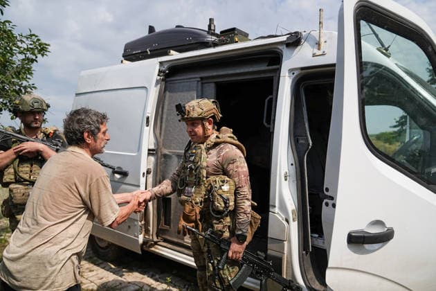 August 19, 2026, Serhiivka, Donetsk Oblast, Ukraine: Gennady Yudin (right), head of the White Angels crew in the Donetsk region, chats with a civilian waiting to be evacuated from the village of Serhiivka, east of Kramatorsk, in the Donbas region, Ukraine, on August 19, 2026. The White Angels crew, composed of police officers, evacuate people from the frontline towns and villages. Serhiivka Ukraine - ZUMAa252 20260819_zip_a252_001 Copyright: xDavidxAllignonx