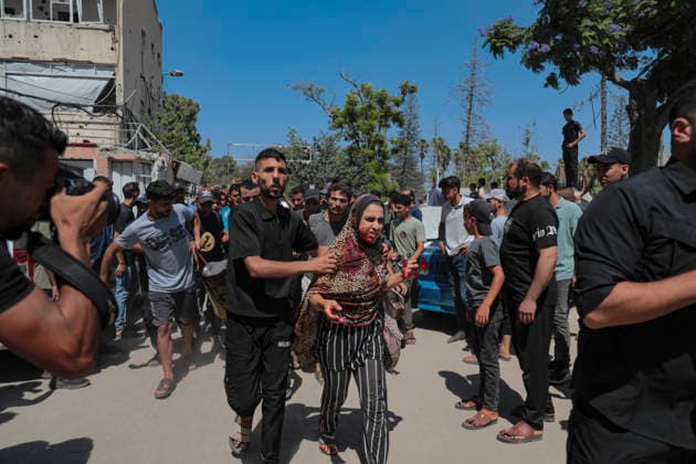 Gaza City Strike Kills Palestinians A woman is assisted through a crowd after an Israeli strike near the municipal park in central Gaza City, the Gaza Strip, on August 19, 2026. At least nine Palestinians were killed and more than 15 others were wounded in the strike, including women and children, according to an initial toll. The strike came shortly after another Israeli attack targeted the municipal police command headquarters in Gaza City. Gaza Gaza Strip Palestinian Territories Copyright: xEyadxAzamx