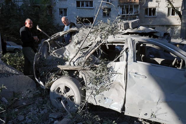 Two men look at a crushed car outside an apartment block in the Solomianskyi district, damaged by a Russian missile attack, Kyiv, Ukraine, August 20, 2026. High-rise residential buildings, a children’s hospital, a school, utility and warehouse facilities, garages, and cars were damaged in the district as a result of Russia’s overnight large-scale combined strike on the capital. Power grid infrastructure was also affected, causing an outage. In Kyiv, the attack claimed the lives of at least 13 people, including two children. The Russian military targeted the city with ballistic missiles, Kalibr cruise missiles, Kh-101s, and Zircon hypersonic cruise missiles. (Photo by Oleksandr Klymenko Ukrinform) Aftermath of Russian strike in Solomianskyi  Copyright: xOleksandrxKlymenkox