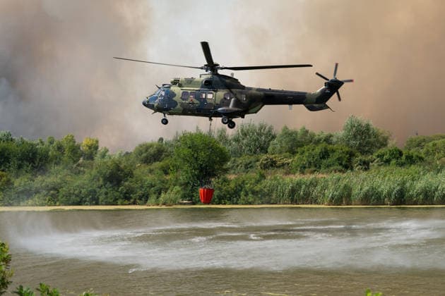 August 20, 2026, Grebenac, Vojvodina, Serbia: 2026820, Grebenac, Serbia - A massive wildfire that has been burning for weeks in the Deliblatska pescara, Special Nature Reserve has reached the village of Grebenac, as locals, firefighters, and military helicopters battle to bring the blaze under control. A military helicopter equipped with a Bambi bucket collects water from a river to drop on the burning forest. Grebenac Serbia - ZUMAd223 20260820_zip_d223_013 Copyright: xMarkoxDimicx