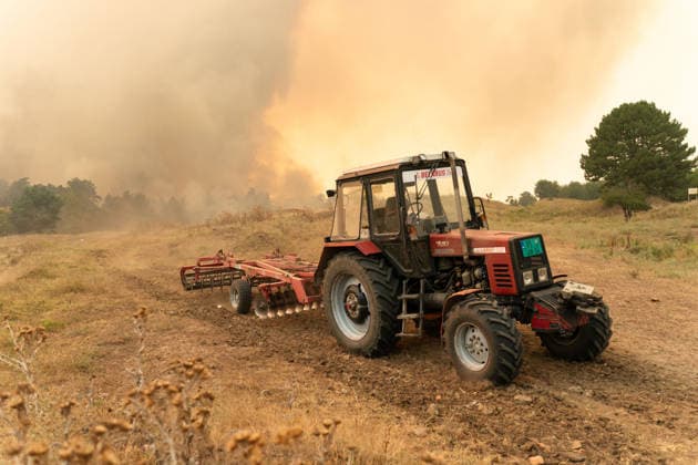 August 20, 2026, Grebenac, Vojvodina, Serbia: 2026820, Grebenac, Serbia - A massive wildfire that has been burning for weeks in the Deliblatska pescara, Special Nature Reserve has reached the village of Grebenac, as locals, firefighters, and military helicopters battle to bring the blaze under control. A local resident uses a tractor to plow a dry field, creating a makeshift firebreak to stop the advancing flames. Grebenac Serbia  - ZUMAd223 20260820_zip_d223_023 Copyright: xMarkoxDimicx