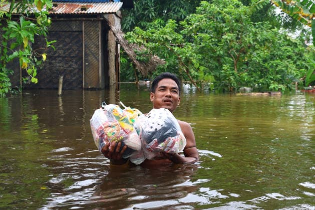 August 20, 2026, Ngathaingchaung, Ayeyarwady Region, Myanmar: A man carries relief supplies donated by rescue teams through floodwaters to higher ground in Ngathaingchaung Township, Ayeyarwady Region, Myanmar..In Laymyethna Township, Ayeyarwady Region, the Ngawun River embankment collapsed on July 31, leaving nearby towns including Hinthada, Yegyi, Ngathaingchaung, Kyonpyaw and Kyaunggon still inundated for three weeks, affecting tens of thousands of people, officials said. Ngathaingchaung Myanmar  - ZUMAn324 20260820_zip_n324_015 Copyright: xAyexMyaxNaingx
