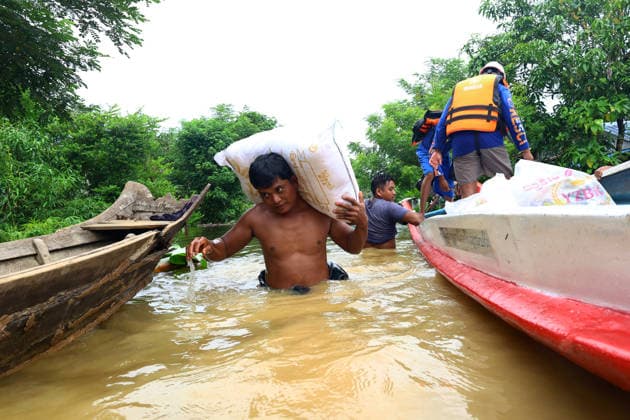 August 20, 2026, Ngathaingchaung, Ayeyarwady Region, Myanmar: A man carries a donated rice sack through floodwaters to higher ground with the help of rescue teams in Ngathaingchaung Township, Ayeyarwady Region, Myanmar..In Laymyethna Township, Ayeyarwady Region, the Ngawun River embankment collapsed on July 31, leaving nearby towns including Hinthada, Yegyi, Ngathaingchaung, Kyonpyaw and Kyaunggon still inundated for three weeks, affecting tens of thousands of people, officials said. Ngathaingchaung Myanmar  - ZUMAn324 20260820_zip_n324_016 Copyright: xAyexMyaxNaingx