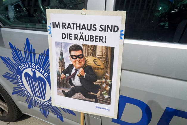 CNTV POLIZEIDEMO- Polizisten und Angestellte der Polizei demonstrieren Ca.100 Teilnehmer haben mit Schilder Bilder mit dem Finanzsenator Dressel als Raeuber Fahnen am Hamburger Adolfsplatz gegen die Sparmassnahmen Kuerzungen und Abschaffung einiger Dienststellen demonstriert am 21.AUGUST2026 in Hamburg Hamburg Deutschland *** CNTV POLICE PROTEST Police officers and police employees protest. Approximately 100 participants demonstrated at Hamburg s Adolfsplatz on August 21, 2026, carrying signs and banners depicting Finance Senator Dressel as a robber, to protest the austerity measures, budget cuts, and the closure of some police stations in Hamburg, Hamburg, Germany