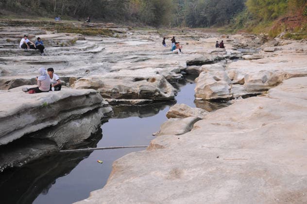 Rocky cliffs revealed after water level drop in Bogowonto River of Purworejo PURWOREJO, CENTRAL JAVA - AUGUST 22: Residents observe rocks and the rocky riverbed as the water level of the Bogowonto River drops during the dry season in Purworejo, Central Java, on August 22, 2026. The riverbed reveals unique wadas rock formations and natural rock carvings created by water erosion, resembling a miniature Grand Canyon stretching one kilometer. The river’s low water level is a result of the five-month-long dry season; normally, the Bogowonto River’s water level reaches five to six meters, covering the rocks and cliffs. Dasril Roszandi Anadolu Purworejo Indonesia. Editorial use only. Please get in touch for any other usage.  Copyright: x2026xAnadoluxDasrilxRoszandix