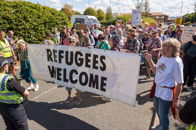 August 22, 2026, Gloucester, Gloucestershire, UK: Gloucester, UK. Counter protesters hold up a sign reading Ã¢â‚¬oeREFUGEES WELCOMEÃ¢â‚¬Â while a group called Gloucester Patriots protest outside the Ibis Hotel in Bristol where asylum seekers and migrants are being accommodated. Gloucester UK  - ZUMAl94_ 20260822_zaf_l94_005 Copyright: xSimonxChapmanx