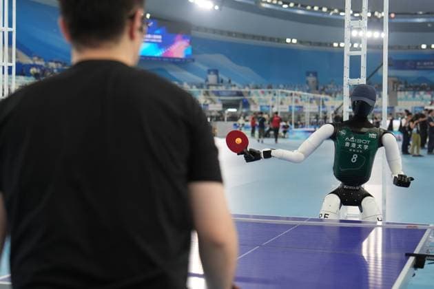 (260822) -- BEIJING, Aug. 22, 2026 -- A humanoid robot plays table tennis with a man before the opening ceremony of the 2nd World Humanoid Robot Games in Beijing, capital of China, Aug. 22, 2026. ) (SP)CHINA-BEIJING-WORLD HUMANOID ROBOT GAMES-OPENING CEREMONY (CN) JuxHuanzong 