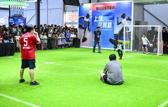 (260822) -- BEIJING, Aug. 22, 2026 -- A robot takes a penalty kick as a boy plays as the goalkeeper at the 2026 World Robot Conference in Beijing, capital of China, Aug. 22, 2026. The conference, which runs from Wednesday through Sunday, has drawn more than 300 exhibitors from 26 countries, with over 3,000 products on display, including more than 300 debuts. Many people visited the conference on Saturday, the first open day of the event. ) CHINA-BEIJING-WORLD ROBOT CONFERENCE (CN) ChenxYehua 