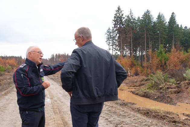 Bundeskanzler Merz besucht Waldbrandgebiet Huertgenwald Feuerwehrsprecher Peter Berndgen erlaeutert Bundeskanzler Friedrich Merz das verbrannte Gebiet bei der Besichtigung des ehemaligen Waldbrandgebiet in Huertgenwald, , 22.08.2026 Huertgenwald (Kreis Dueren) Nordrhein-Westfalen Deutschland *** Chancellor Merz Visits the Huertgenwald Forest Fire Site Fire Department Spokesperson Peter Berndgen explains the burned area to Chancellor Friedrich Merz during a tour of the former forest fire site in Huertgenwald, August 22, 2026, Huertgenwald, Düren District, North Rhine-Westphalia, Germany