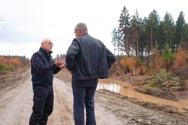 Bundeskanzler Merz besucht Waldbrandgebiet Huertgenwald Feuerwehrsprecher Peter Berndgen erlaeutert Bundeskanzler Friedrich Merz das verbrannte Gebiet bei der Besichtigung des ehemaligen Waldbrandgebiet in Huertgenwald, , 22.08.2026 Huertgenwald (Kreis Dueren) Nordrhein-Westfalen Deutschland *** Chancellor Merz Visits the Huertgenwald Forest Fire Site Fire Department Spokesperson Peter Berndgen explains the burned area to Chancellor Friedrich Merz during a tour of the former forest fire site in Huertgenwald, August 22, 2026, Huertgenwald, Düren District, North Rhine-Westphalia, Germany