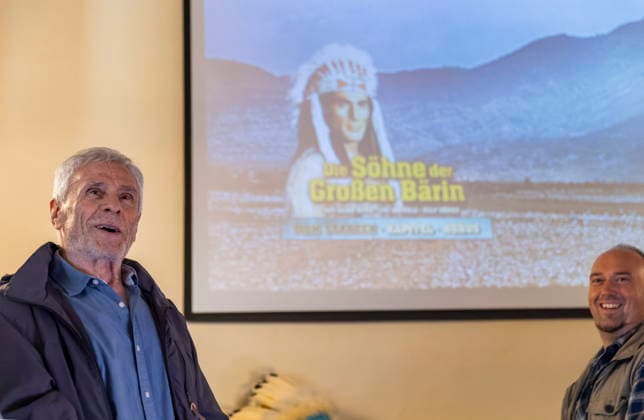 DEFA Schauspieler Gojko MitiÄ‡ im Karl May Museum Radebeul Die Rückkehr der Blackfoot-Frau: Namensweihe mit Gojko MitiÄ‡ im Karl May Museum Radebeul. Nach drei Jahren aufwändiger Restaurierung kehrt die beliebte Blackfoot-Frau nun am 22. August zurück in die Villa Bärenfett. Die Figur wurde auf den Namen Sitopanaki getauft, diesen Namen trug die Filmrolle der Frau welche die Partnerin von Mitic im Indianerfilm die Söhne der Großen Bärin trug. Radebeul Sachsen Deutschland *** DEFA Actor Gojko Mitic at the Karl May Museum in Radebeul: The Return of the Blackfoot Woman—A Naming Ceremony with Gojko Mitic at the Karl May Museum in Radebeul After three years of extensive restoration, the beloved Blackfoot woman is now returning to Villa