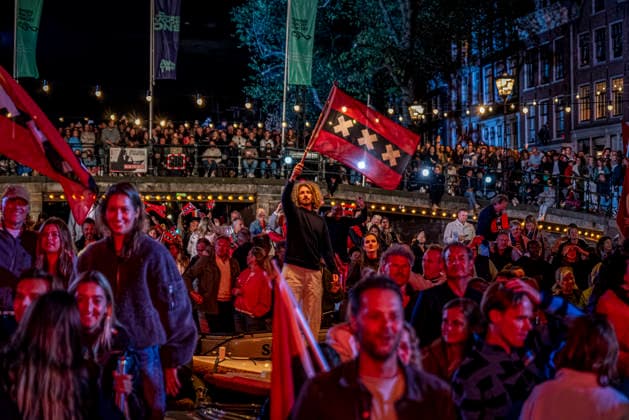 August 22, 2026, Amsterdam, North Holland, The Netherlands: Audience members wave the flag of the city of Amsterdam as musicians perform the song De Stad Amsterdam (The City of Amsterdam). 22 August 2026, in Amsterdam, the Netherlands. The 44th edition of the Prinsengrachtconcert takes place on a floating stage on the Prinsengracht in front of Hotel Pulitzer, the largest free open-air classical music concert in the Netherlands. Amsterdam The Netherlands - ZUMAp202 20260822_zip_p202_030 Copyright: xJamesxPetermeierx