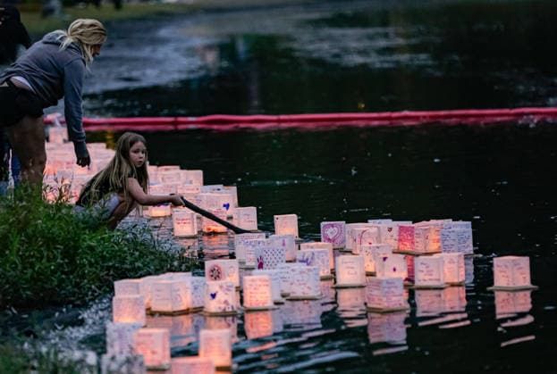 (260823) -- COQUITLAM, Aug. 23, 2026 -- A girl releases an illuminated lantern onto the water during the Water Lantern Festival at Town Centre Park in Coquitlam, British Columbia, Canada, Aug. 22, 2026. The festival invited participants to decorate lanterns with messages of hope, dreams and remembrance before releasing them onto the water. (Photo by Xinhua) CANADA-COQUITLAM-WATER LANTERN FESTIVAL LiangxSen 