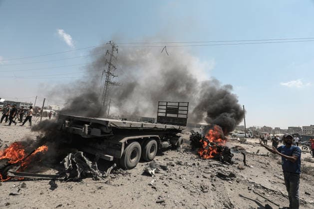 Palestinians look at a burning lorry between the areas of Maghazi and al-Zawayda following an Israeli strike, carried out after the military warned Palestinian residents to evacuate the area of al-Zawayda, in the central Gaza Strip, on Sunday on August 23, 2026. Israeli strikes in the central Gaza Strip killed three people including a child, rescuers said.  GAZ2026082310 AbedxSalhi