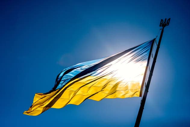 The sun shines through the Ukrainian flag flying on the flagpole during the flag-raising ceremony at the National Museum of the History of Ukraine in the Second World War Memorial Complex on National Flag Day, Kyiv, Ukraine, August 23, 2026. (Photo by Yevhen Kotenko Ukrinform) Raising of State Flag of Ukraine in Kyiv  Copyright: xYevhenxKotenkox