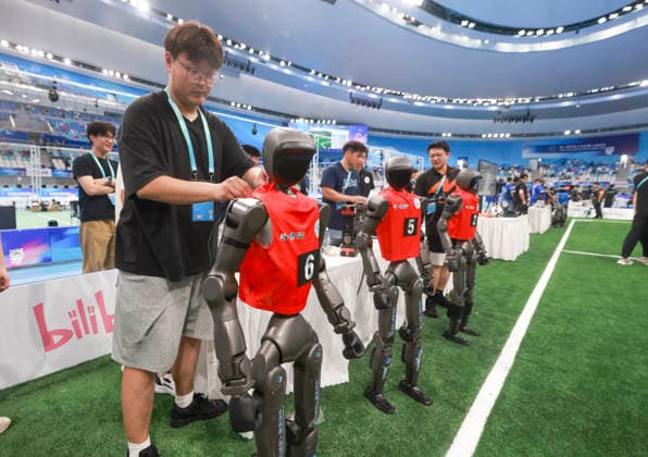BEIJING, CHINA - AUGUST 23: Technicians check robot players during the quarterfinal match of the soccer event - 5v5 Large Size Group on day 2 of the 2nd World Humanoid Robot Games at National Speed Skating Oval on August 23, 2026 in Beijing, China.  Copyright: xChinaxNewsxServicex 111661701668