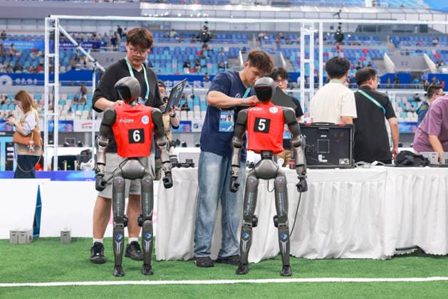 BEIJING, CHINA - AUGUST 23: Technicians check robot players during the quarterfinal match of the soccer event - 5v5 Large Size Group on day 2 of the 2nd World Humanoid Robot Games at National Speed Skating Oval on August 23, 2026 in Beijing, China.  Copyright: xChinaxNewsxServicex 111661701845