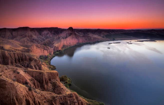 Vibrant sunrise over a lake and eroded red cliffs Burujón, Toledo, Spain CR_HEBU260812-2098488-01 ,model released, Symbolfoto ,property released