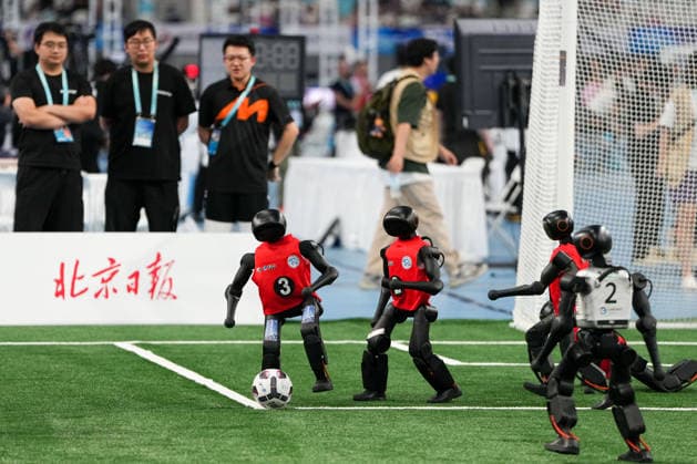 (260824) -- BEIJING, Aug. 24, 2026 -- Robots (L) of CAU Mountain&Sea competes with robots of B-human during the 5v5 Medium Robot Group of Soccer match of the 2nd World Humanoid Robot Games in Beijing, capital of China, Aug. 24, 2026. ) (SP)CHINA-BEIJING-WORLD HUMANOID ROBOT GAMES (CN) JuxHuanzong 