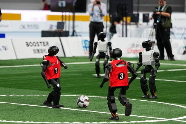 (260824) -- BEIJING, Aug. 24, 2026 -- Robots (L) of CAU Mountain&Sea competes with robots of B-human during the 5v5 Medium Robot Group of Soccer match of the 2nd World Humanoid Robot Games in Beijing, capital of China, Aug. 24, 2026. ) (SP)CHINA-BEIJING-WORLD HUMANOID ROBOT GAMES (CN) JuxHuanzong 