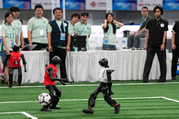 (260824) -- BEIJING, Aug. 24, 2026 -- Robots (L) of CAU Mountain&Sea competes with robots of B-human during the 5v5 Medium Robot Group of Soccer match of the 2nd World Humanoid Robot Games in Beijing, capital of China, Aug. 24, 2026. ) (SP)CHINA-BEIJING-WORLD HUMANOID ROBOT GAMES (CN) JuxHuanzong 
