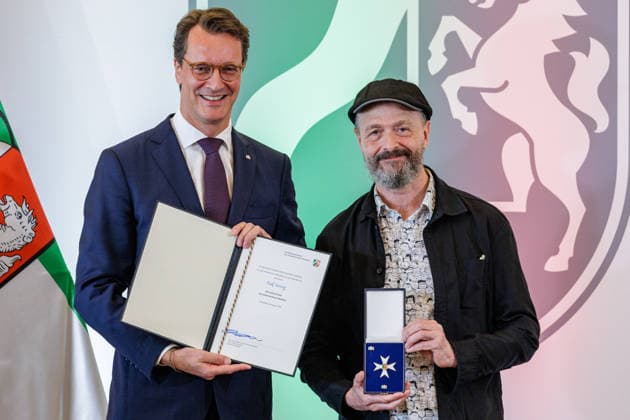 24.08.2026. Düsseldorf. (l-r) NRW-Ministerpräsident Hendrik Wüst und Ralf König bei der Verleihung des Verdienstordens des Landes Nordrhein-Westfalen anlässlich des 80. Landesgeburtstages. Ralf König hat als Autor und Comiczeichner mit seinen gesellschaftskritischen Cartoons Debatten über Sexualität, Religion, Politik und Rollenbilder angestoßen. Seit den 1980er Jahren hat er mit seinen Comics zur sexuellen Aufklärung beigetragen und Tabus aufgebrochen. Mit seinem Engagement für Kunstfreiheit und Menschenrechte hat er zudem gesellschaftliche Verantwortung übernommen. Düsseldorf Staatskanzlei Nordrhein-Westfalen Deutschland *** August 24, 2026, Düsseldorf NRW Minister President Hendrik Wüst and Ralf König at the award cerem