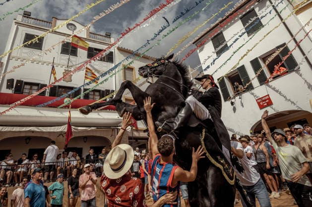 August 24, 2026, Ferreries, Menorca Balearic Islands, Spain: A caixer, or horse rider, rears his horse amid a cheering crowd during the traditional Jaleo at the Sant Bartomeu Festival in Ferreries. Ferreries Spain  - ZUMAo105 20260824_fap_o105_011 Copyright: xMatthiasxOesterlex