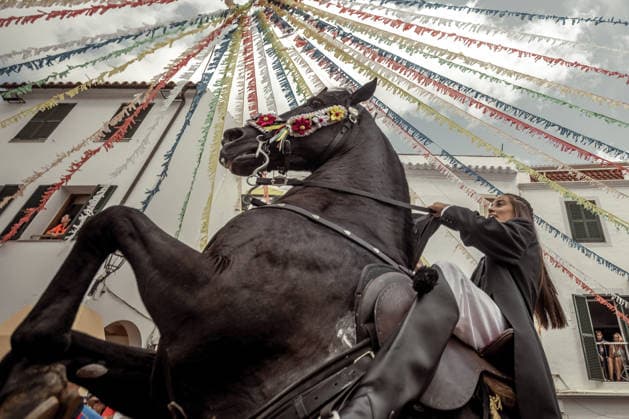 August 24, 2026, Ferreries, Menorca Balearic Islands, Spain: A caixer, or horse rider, rears his horse amid a cheering crowd during the traditional Jaleo at the Sant Bartomeu Festival in Ferreries. Ferreries Spain  - ZUMAo105 20260824_fap_o105_014 Copyright: xMatthiasxOesterlex